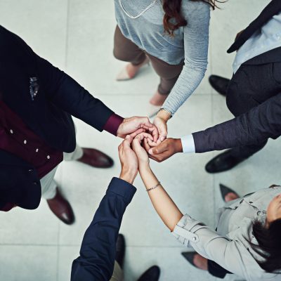 Cropped shot of a diverse team of colleagues joining their hands together in unity